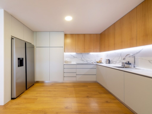 Cozinha com móveis brancos e frigorífico americano
